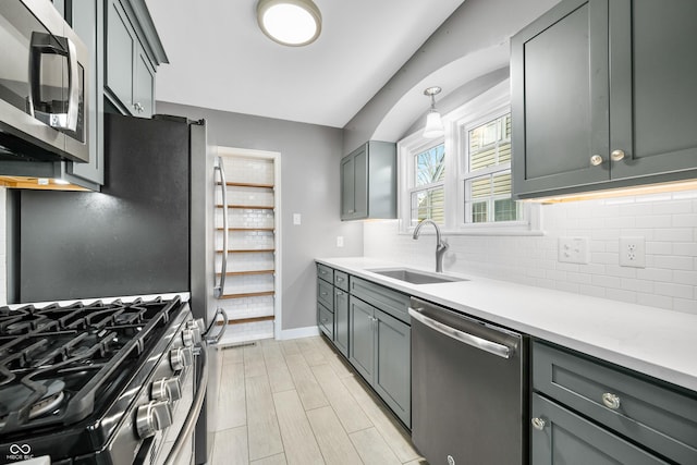 kitchen with light countertops, a sink, backsplash, and stainless steel appliances