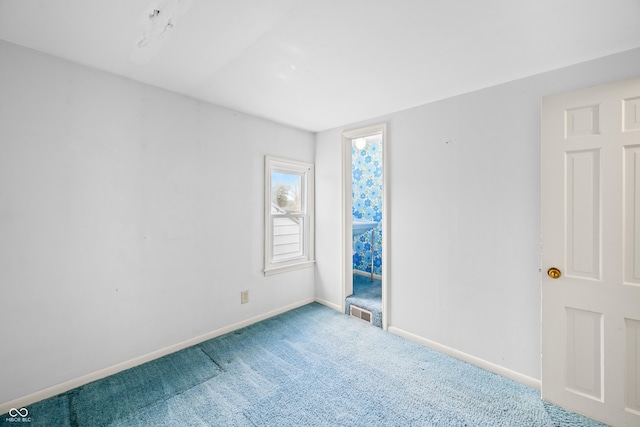 carpeted empty room with visible vents and baseboards