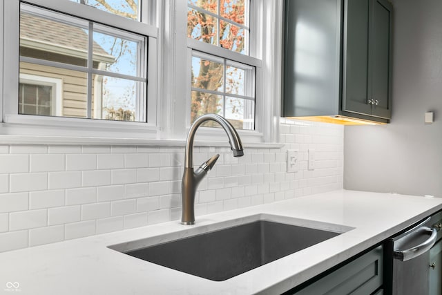 room details featuring a sink, gray cabinetry, light stone countertops, backsplash, and stainless steel dishwasher