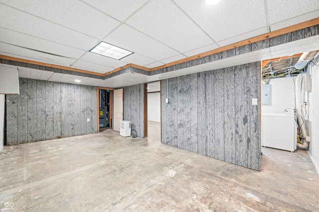 finished below grade area with washer / dryer, a paneled ceiling, and electric panel