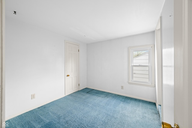 carpeted spare room featuring baseboards