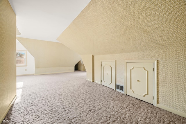 bonus room featuring vaulted ceiling, visible vents, carpet flooring, wallpapered walls, and baseboards