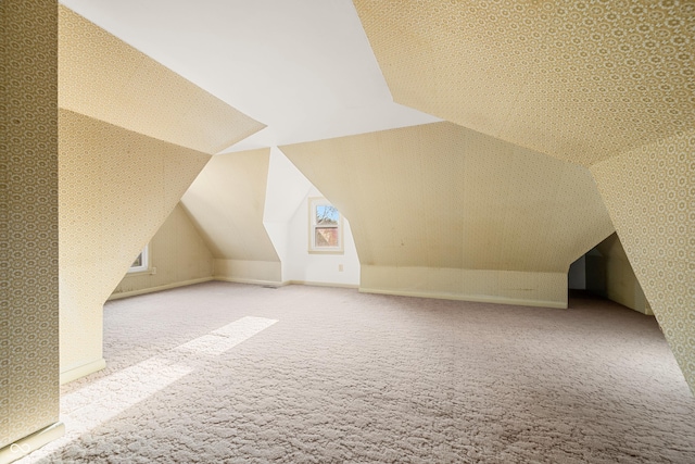 bonus room with wallpapered walls, baseboards, vaulted ceiling, and carpet