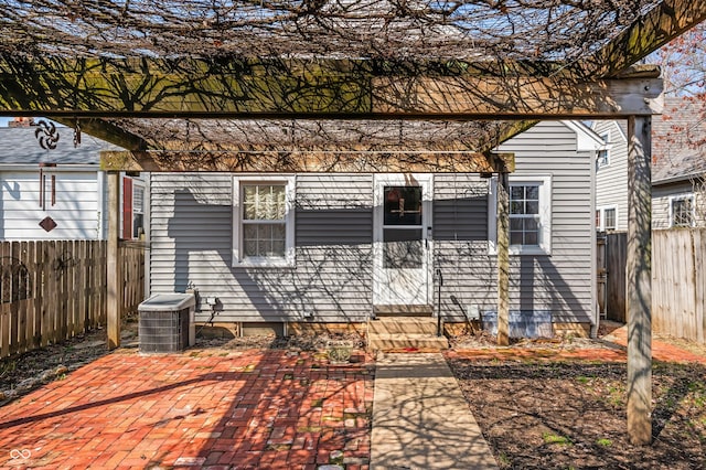 view of front of house featuring entry steps, a patio area, fence, and central AC