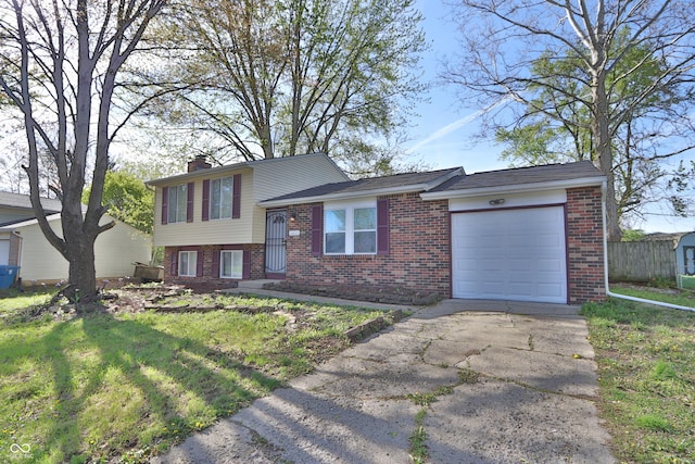 split level home with a chimney, brick siding, a garage, a front lawn, and concrete driveway