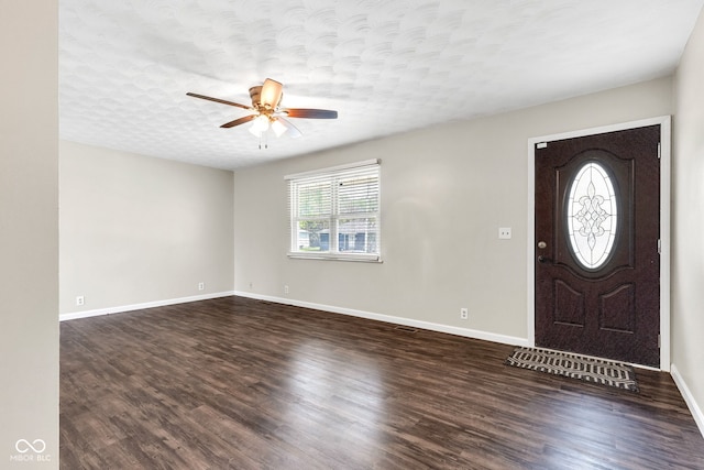 foyer with baseboards, a textured ceiling, dark wood-style flooring, and ceiling fan