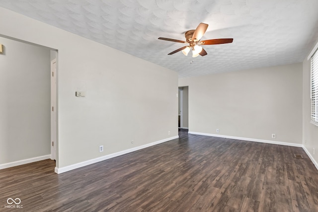 unfurnished room with baseboards, a ceiling fan, and dark wood-style floors