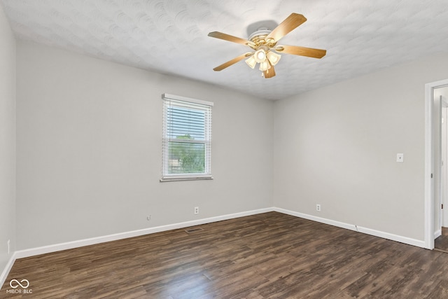 empty room featuring baseboards, ceiling fan, and dark wood-style flooring