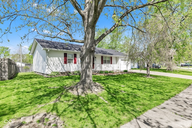 ranch-style home with fence, concrete driveway, a garage, and a front yard