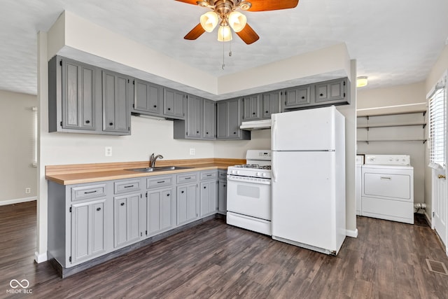 kitchen featuring a sink, gray cabinetry, under cabinet range hood, and white appliances