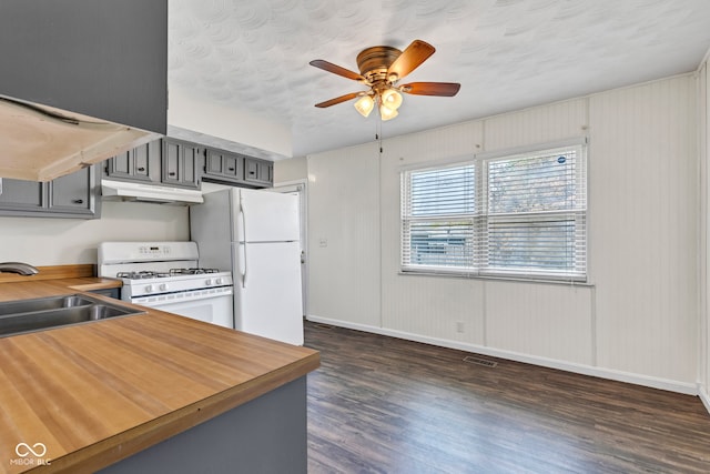 kitchen featuring white appliances, dark wood-type flooring, gray cabinets, under cabinet range hood, and wood counters