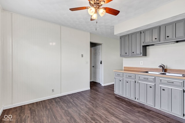 kitchen featuring a sink, dark wood finished floors, and gray cabinetry