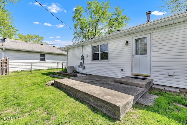 back of property featuring a lawn, fence, and central air condition unit