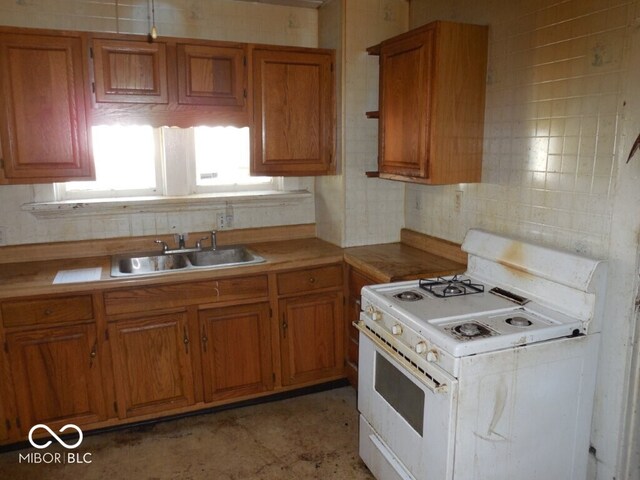 923 Woodview Blvd, Fort Wayne, IN 46806 - kitchen with white gas range oven, light countertops, a sink, tasteful backsplash, and brown cabinets