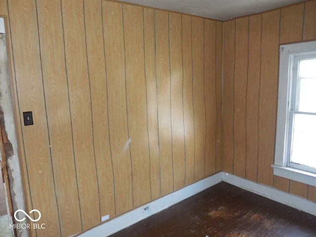 923 Woodview Blvd, Fort Wayne, IN 46806 - unfurnished room featuring a wealth of natural light, baseboards, wooden walls, and dark wood finished floors