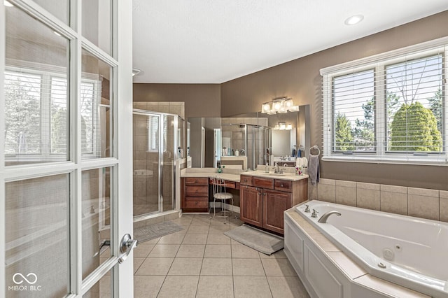 full bathroom featuring vanity, a whirlpool tub, tile patterned flooring, and a stall shower