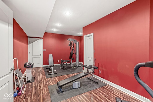 workout area with recessed lighting, wood finished floors, and baseboards