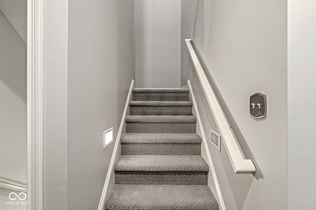 stairs with baseboards and carpet floors