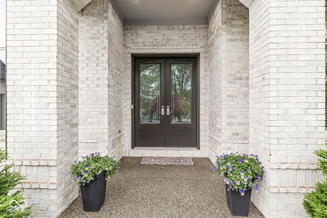 property entrance featuring french doors and brick siding