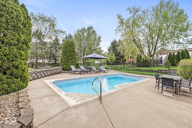 view of swimming pool with fence, playground community, a fenced in pool, outdoor dining area, and a patio area