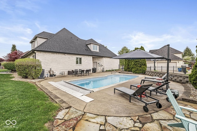 view of pool featuring a yard, a patio, a fenced in pool, and fence