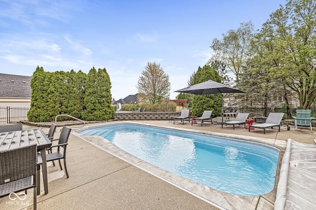 view of swimming pool featuring outdoor dining space, fence, a fenced in pool, and a patio area