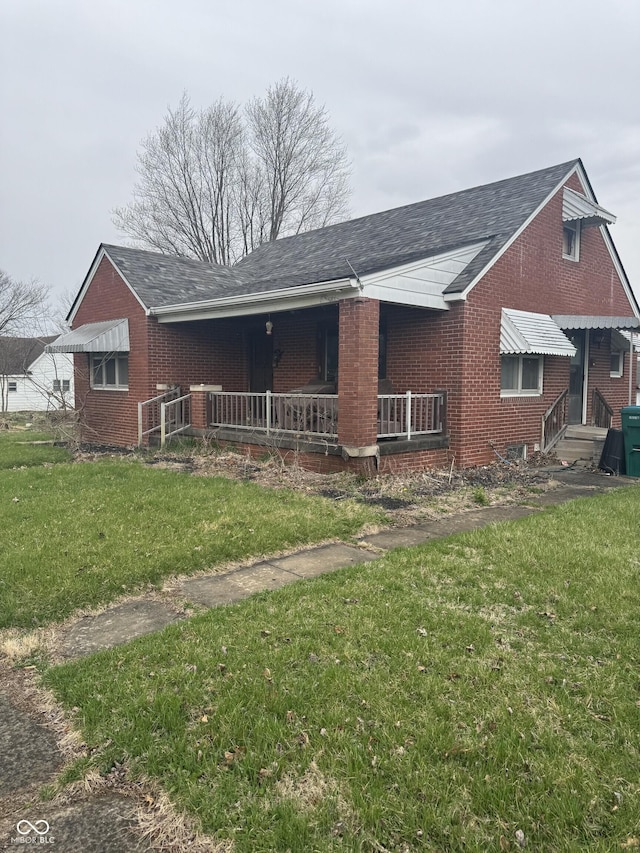 view of front of property featuring brick siding, a porch, and a front yard