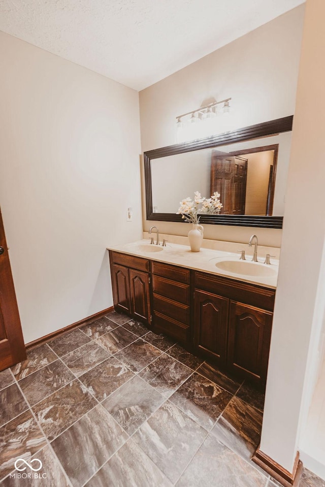 6712 Forrest Commons Blvd, Indianapolis, IN 46227 - bathroom featuring double vanity, a sink, and baseboards