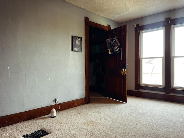 310 E Central Ave, Greensburg, IN 47240 - unfurnished room with light carpet, plenty of natural light, baseboards, and a textured ceiling