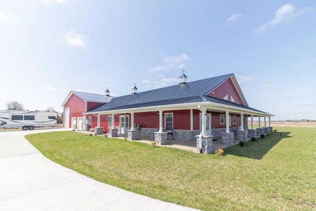 8267 W County Road 350 S, Shirley, IN 47384 - view of front of home featuring stone siding, metal roof, concrete driveway, a front yard, and covered porch