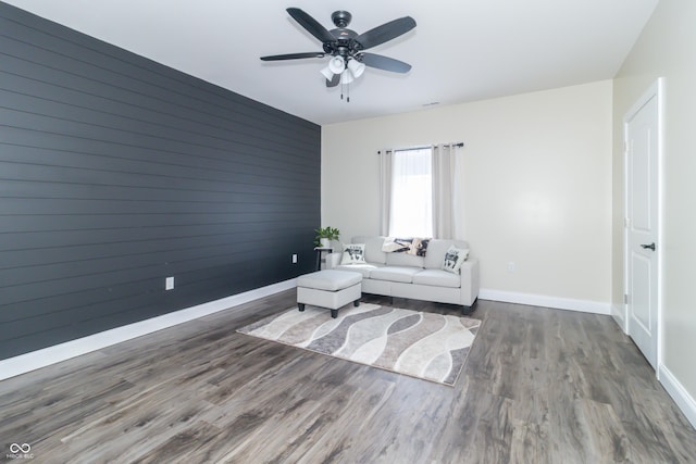 8267 W County Road 350 S, Shirley, IN 47384 - living room with wooden walls, baseboards, ceiling fan, wood finished floors, and an accent wall