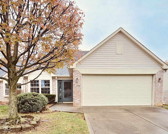 10949 Harness Way, Indianapolis, IN 46239 - view of front of property with brick siding, driveway, and a garage