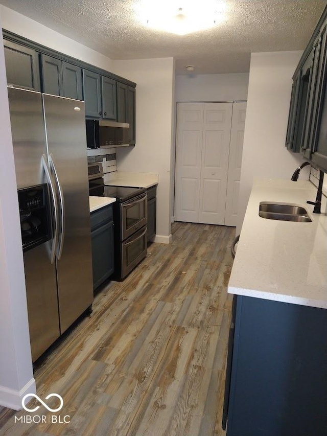 1447 Rebecca Ln, Franklin, IN 46131 - kitchen with stainless steel appliances, light wood finished floors, a textured ceiling, and light stone counters