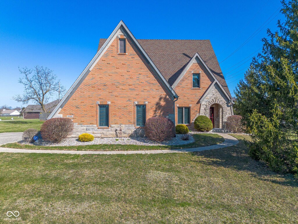 2406 Chrystal Woods Dr, Kokomo, IN 46901 - tudor house featuring stone siding, brick siding, and a front lawn