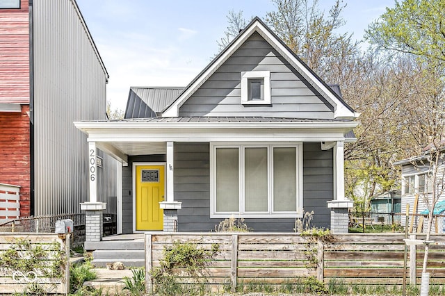 2006 Lexington Ave, Indianapolis, IN 46203 - view of front of property with metal roof, covered porch, and a fenced front yard