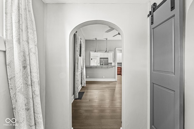 2006 Lexington Ave, Indianapolis, IN 46203 - hallway featuring arched walkways, a barn door, and dark wood-style floors