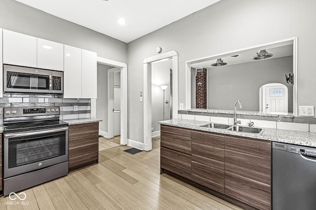 2006 Lexington Ave, Indianapolis, IN 46203 - kitchen with light wood-style flooring, white cabinets, modern cabinets, stainless steel appliances, and a sink