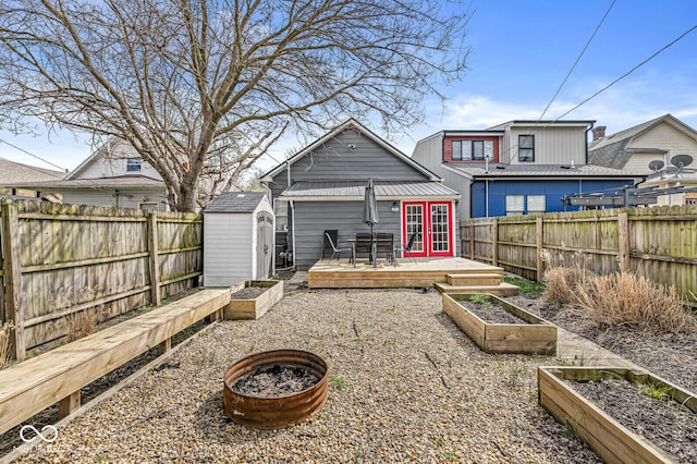 2006 Lexington Ave, Indianapolis, IN 46203 - back of house with a fenced backyard, an outdoor structure, a garden, french doors, and a deck