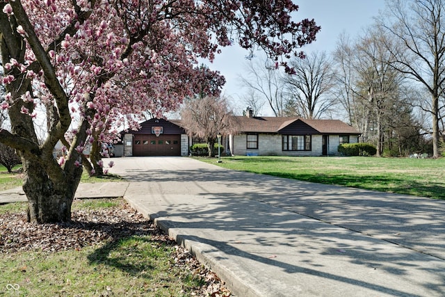 6047 W 56th St, Indianapolis, IN 46254 - ranch-style house featuring stone siding, an attached garage, a chimney, concrete driveway, and a front yard