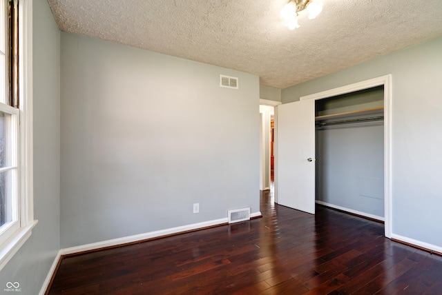 6047 W 56th St, Indianapolis, IN 46254 - unfurnished bedroom with wood-type flooring, a closet, baseboards, and visible vents