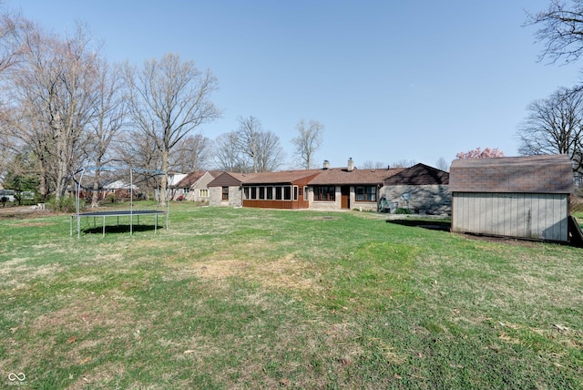 6047 W 56th St, Indianapolis, IN 46254 - view of yard featuring a storage shed, an outbuilding, a sunroom, and a trampoline