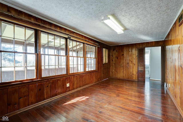 6047 W 56th St, Indianapolis, IN 46254 - empty room with hardwood / wood-style floors, wooden walls, and a textured ceiling