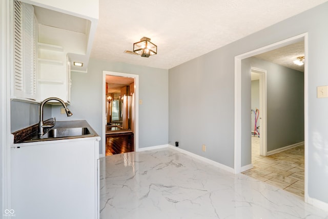6047 W 56th St, Indianapolis, IN 46254 - interior space featuring marble finish floor, a sink, baseboards, and a textured ceiling