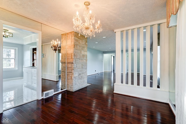 6047 W 56th St, Indianapolis, IN 46254 - interior space with a textured ceiling, visible vents, hardwood / wood-style flooring, baseboards, and an inviting chandelier