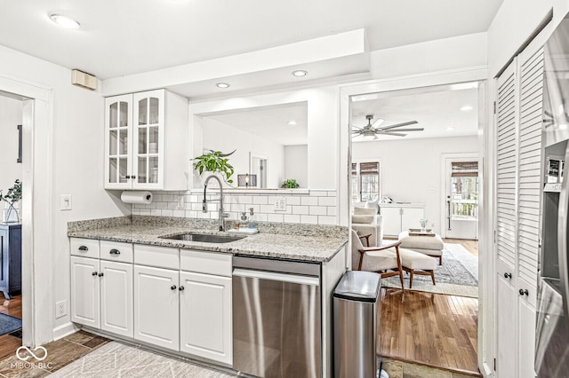 5028 Graceland Ave, Indianapolis, IN 46208 - kitchen featuring a sink, white cabinetry, a ceiling fan, stainless steel dishwasher, and glass insert cabinets