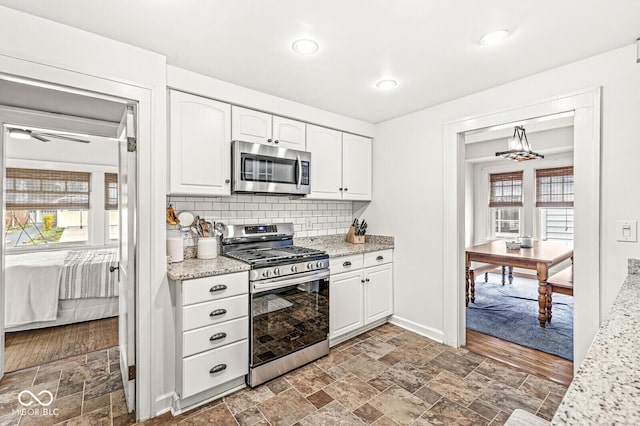 5028 Graceland Ave, Indianapolis, IN 46208 - kitchen with white cabinetry, appliances with stainless steel finishes, and a wealth of natural light