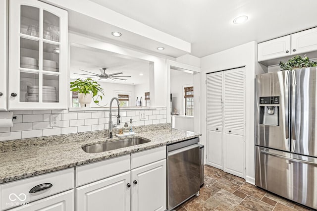 5028 Graceland Ave, Indianapolis, IN 46208 - kitchen with glass insert cabinets, white cabinetry, tasteful backsplash, a sink, and stainless steel appliances