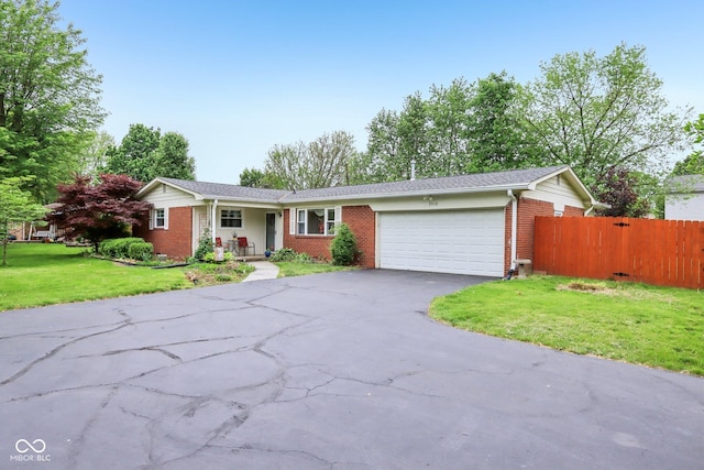 2910 S Sheridan Ave, Indianapolis, IN 46203 - ranch-style home with an attached garage, brick siding, driveway, and covered porch