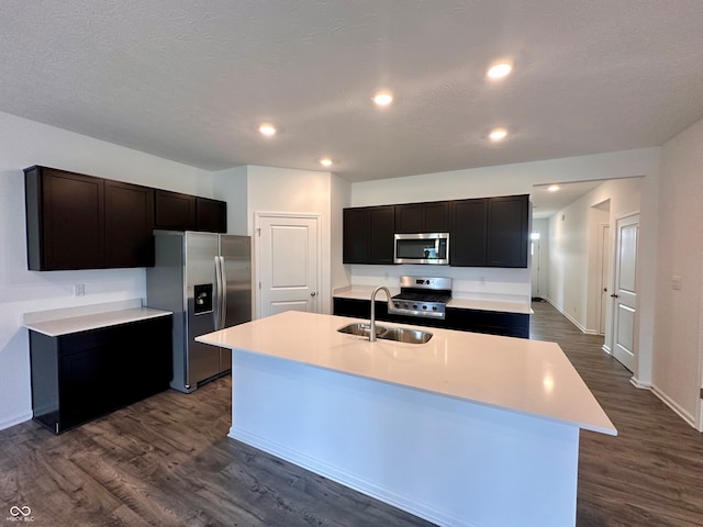 8727 Duncan St, Fortville, IN 46040 - kitchen with appliances with stainless steel finishes, dark wood-type flooring, light countertops, a kitchen island with sink, and recessed lighting