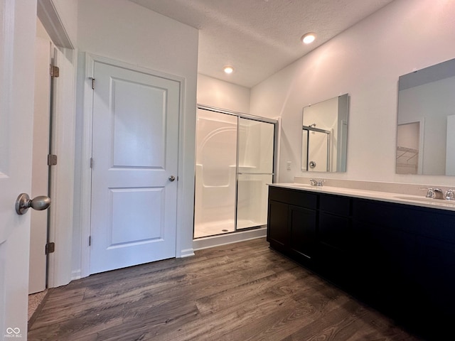 8727 Duncan St, Fortville, IN 46040 - full bath featuring wood finished floors, a shower stall, double vanity, a textured ceiling, and recessed lighting